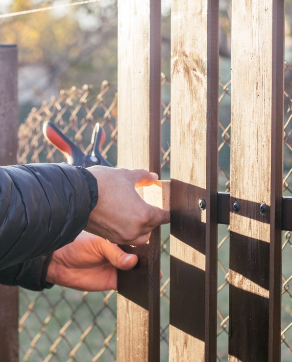 person-repairing-a-wooden-fence-outdoors-during-da-2026-03-24-08-42-54-utc1