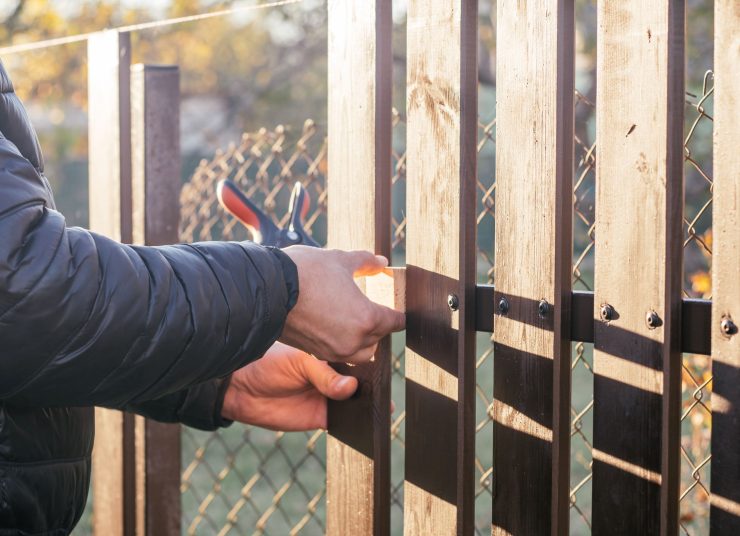 person-repairing-a-wooden-fence-outdoors-during-da-2026-03-24-08-42-54-utc1