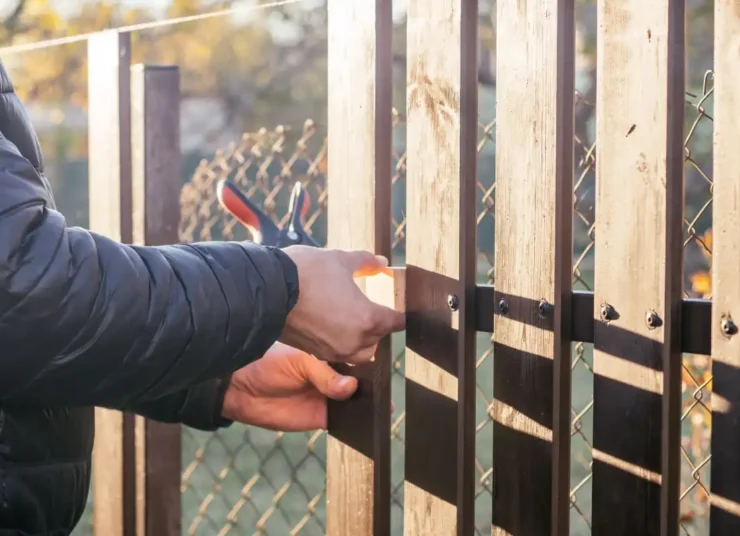 person-repairing-a-wooden-fence-outdoors-during-da-2026-03-24-08-42-54-utc1